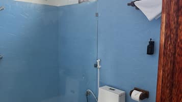 A bathroom with a shower, toilet, and sink.
