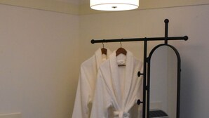 A bathroom with a walk-in shower, a mirror, and a towel rack. - The Bloomberg at Bloomberg Suites (Chanhassen)