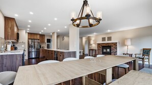 Cozinha moderna com ilha central, eletrodomésticos de aço inoxidável e luminária pendente.