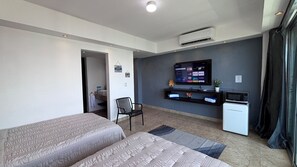 A hotel room with two beds, a TV, a small kitchenette, and a bathroom visible through an open door. - Walk to Coco Bongo, enjoy this condo, great location and nicest beach in Cancun (Cancún)