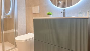 A modern bathroom with a toilet, a shower enclosure, and a vanity with a mirror. - Flatsharing Design Studio - Moka (Milan)