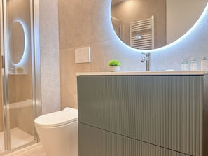 A modern bathroom with a toilet, a shower enclosure, and a vanity with a mirror. - Flatsharing Design Studio - Moka (Milan)