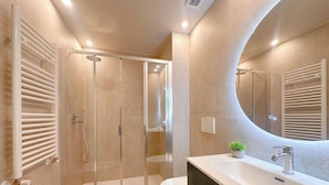 A modern bathroom with a glass-enclosed shower, a white sink with a single faucet, and a large mirror. - Flatsharing Design Studio - Moka (Milan)