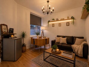 Ein gemütliches Wohnzimmer mit Kamin, Essbereich, Sofa und Couchtisch.