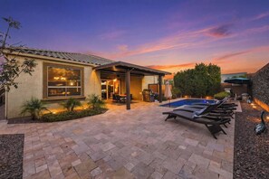 A residential property with a swimming pool, patio area, and a covered outdoor seating space. - Modern 5BR Pool Home Sleeps 15 Walk to Stadium (Glendale)