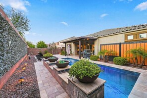 A backyard with a swimming pool, outdoor seating, and a barbecue area. - Modern 5BR Pool Home Sleeps 15 Walk to Stadium (Glendale)