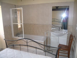 Een badkamer met een bad, een wastafel en een spiegel.