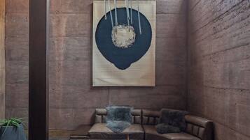 A modern interior with a sectional sofa, a coffee table, and a large abstract painting on the wall.