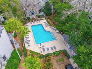 An aerial view of a swimming pool surrounded by lounge chairs and a small garden area. - 3BR Ocean Breeze Escape | Walk to Beach at Coligny (Hilton Head Island)