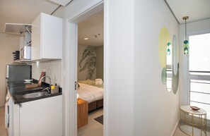A modern kitchen with a built-in microwave, a sink, and a countertop. - Corporate Stays First Living - 907 (Asunción)
