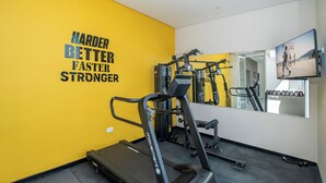 Ein Fitnessstudio mit Laufband, Kraftgeräten und einem motivierenden Spruch an der Wand.