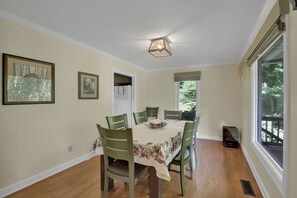 A dining room with a table set for four, surrounded by chairs, a ceiling fan, and framed artwork on the walls. - Private Blue Ridge 3BR Haven, Luxury Hot Tub (Bakersville)