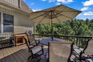 A deck with outdoor furniture, a fan, and a large umbrella. - Private Blue Ridge 3BR Haven, Luxury Hot Tub (Bakersville)