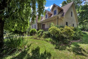 A two-story house with a stone foundation, a front porch, and a well-maintained garden. - Private Blue Ridge 3BR Haven, Luxury Hot Tub (Bakersville)