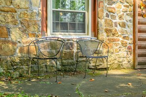 A stone building with a window and two metal chairs outside. - A Peaceful Brown County Getaway Close to the State Park (Nashville)