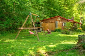 A wooden swing set in a grassy yard with a small wooden structure in the background. - A Peaceful Brown County Getaway Close to the State Park (Nashville)