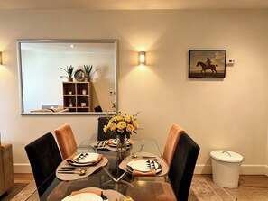 A dining area with a glass table, chairs, and a vase of flowers. - Cosy 2BRs Apt w/AC and balcony near Vauxhall (London)