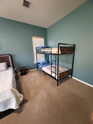 A bedroom with a bunk bed, a single bed, and a small bedside table. - Welcoming 4BR Luxury house with private POOL in charming Forney (Forney)