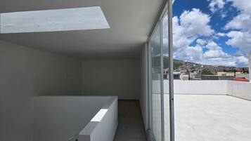 A balcony with a view of a cityscape and a clear sky.