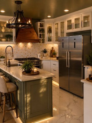 A modern kitchen with a central island, stainless steel appliances, and a decorative light fixture.