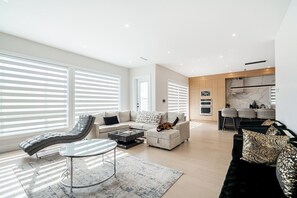 A modern living room with a sofa, a lounge chair, and a coffee table. - Whiterock holiday heaven (Surrey)
