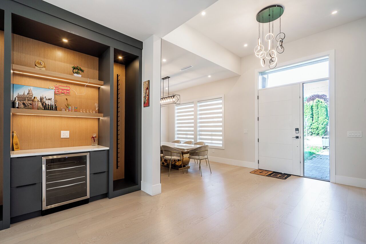 A modern interior with a kitchen area, dining space, and a door leading outside.