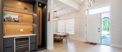 A modern interior with a kitchen area, dining space, and a door leading outside.