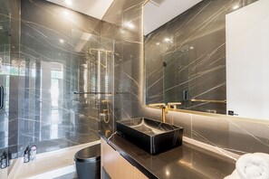 A modern bathroom with a black sink, a glass shower enclosure, and a large mirror. - Whiterock holiday heaven (Surrey)
