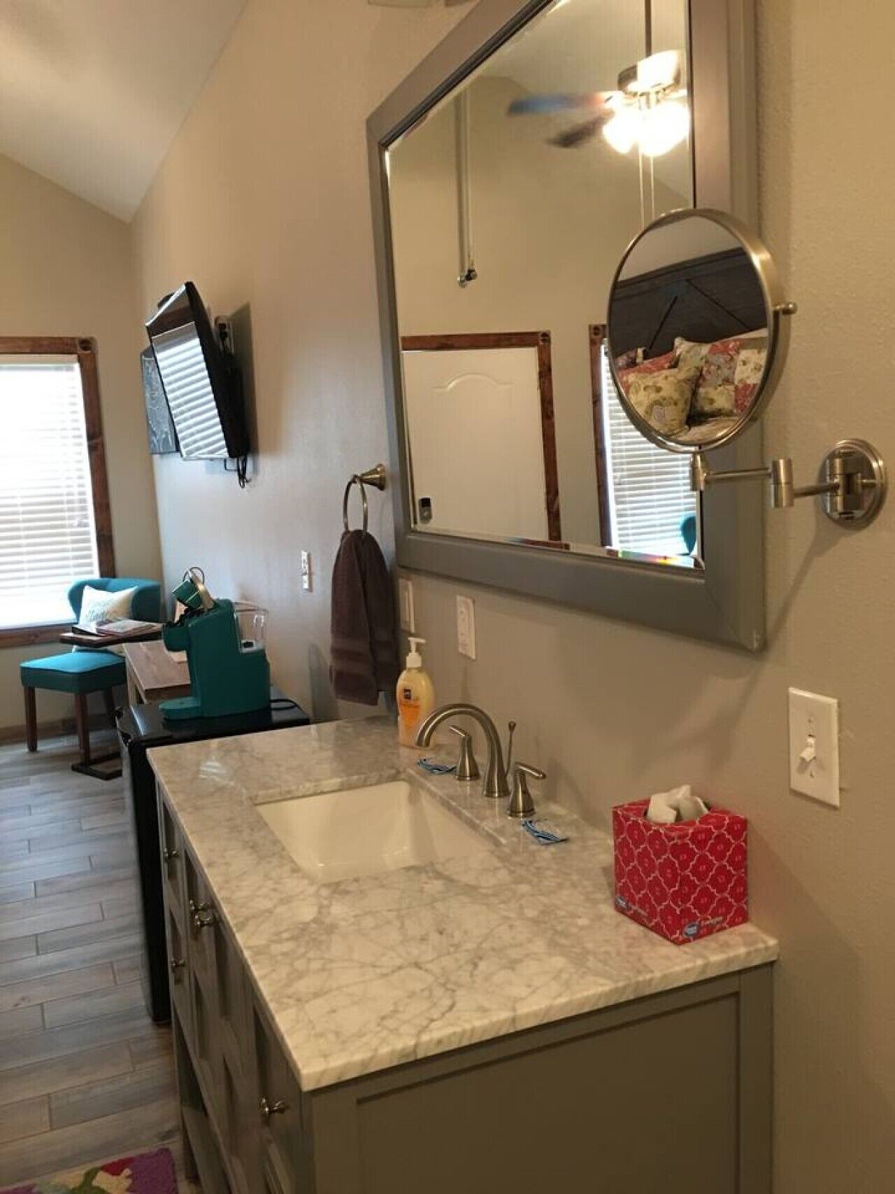 A bathroom with a large mirror, a sink, and a toilet.