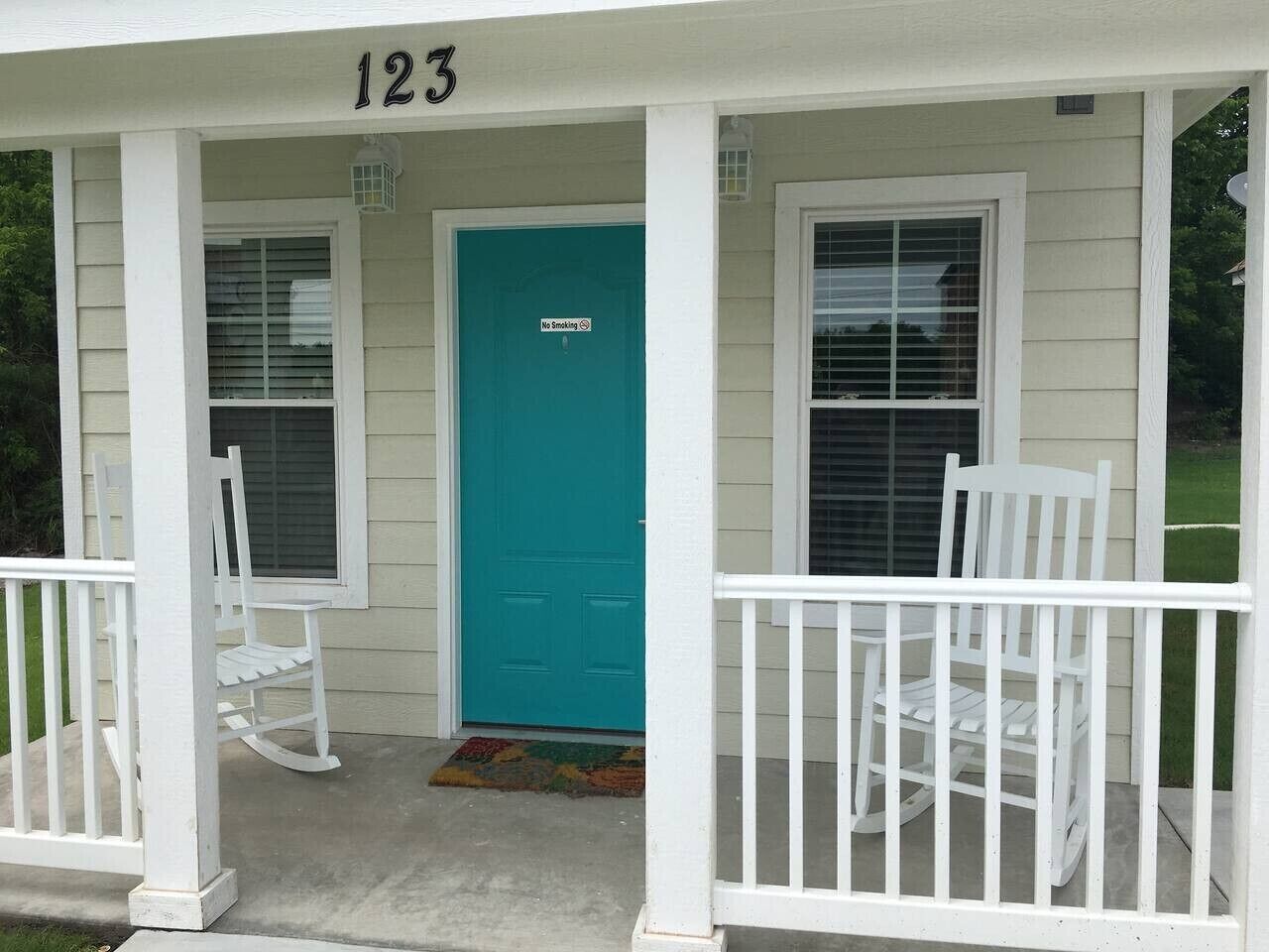 A house with a porch, a turquoise door, and a number '123' above the door.