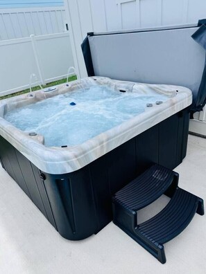 Ein Whirlpool mit integriertem Sitzplatz und einer Stufe zum leichteren Ein- und Ausstieg.