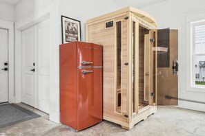 Ein Zimmer mit einem roten Schrank, einem Holzkasten mit Glastür und einem gerahmten Bild an der Wand.