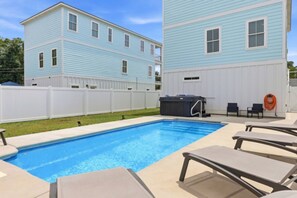 A swimming pool with lounge chairs and a hot tub in a backyard with a white fence and two-story houses. - HoT TuB PooL Sauna 5 BeD Pet Friendly Mansion (Murrells Inlet)
