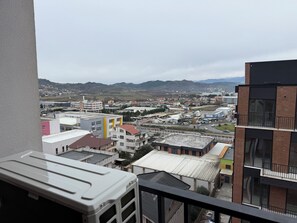 Un paisaje urbano con edificios, una carretera y colinas al fondo.
