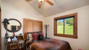 A bedroom with a bed, a desk, a chair, a window, and a ceiling fan. - Dallas Chalet | 7BD 4.5BA with Hot Tub and Views! (Steamboat Springs)