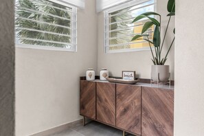 A modern interior with a wooden cabinet, two windows with blinds, and a potted plant. - Stylish, Comfortable, Private townhouse steps to Dover Beach & St. Lawrence Gap (Oistins)