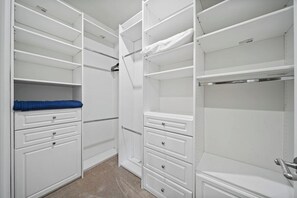 A walk-in closet with open shelving, drawers, and hanging space.