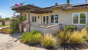 A residential house with a pergola, a stone wall, and a variety of plants. - Wine Country Estate w/ Pool, Spa, Theater & Golf (Temecula)