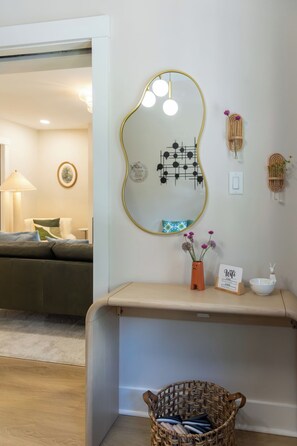 A room with a mirror, a vase with flowers, a WiFi sign, a bowl, and a wicker basket. - Luxury 5BR Shadyside Home Near CMU • Walk to Walnut St & Bakery Square (Pittsburgh)