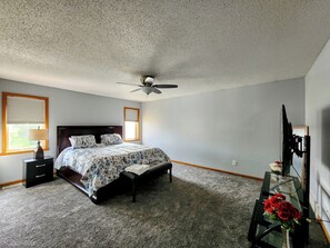 A bedroom with a bed, a nightstand, a desk, a ceiling fan, and a window with blinds. - 3-bedroom house in peaceful Fargo with cool AC breeze (Fargo)