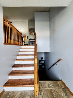 A wooden staircase with white risers leading to a landing. - 3-bedroom house in peaceful Fargo with cool AC breeze (Fargo)