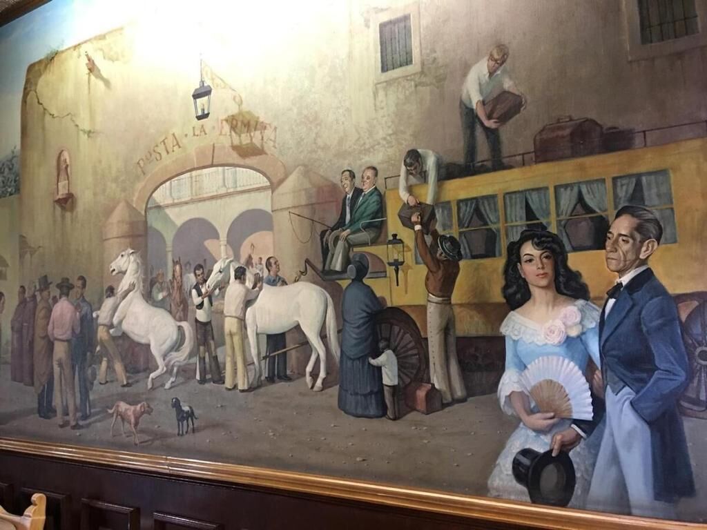 A mural with a horse-drawn carriage, people, and a building labeled 'POSTA LA ROMA'.