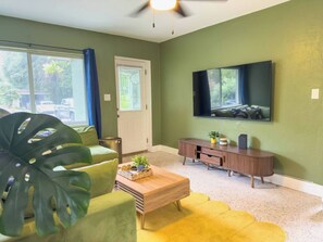 Ein Wohnzimmer mit einer Couch, einem Couchtisch, einem Fernseher und einem Holzschrank.