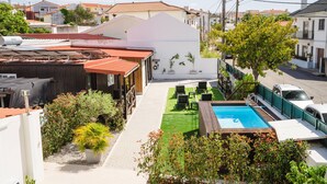 A residential area with a swimming pool, green lawn, and various plants. - II Ninho - Pátio Mariano (Peniche)