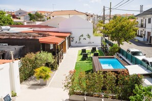 Um bairro residencial com piscina, gramado verde e diversas plantas.