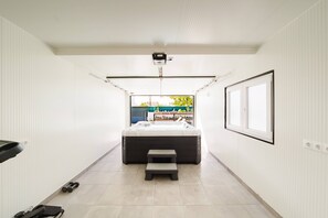 Ein modernes Badezimmer mit einer Badewanne, einer Treinstufe und einem Fenster mit Blick nach draußen.