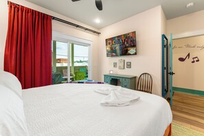 Un dormitorio con cama, ventana, un cuadro, escritorio y silla.