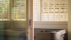 A room with a sliding glass door leading to a balcony with a white fence. - 2BR/2BA Hot Tub Suite • Coat of Many Colors (Sevierville)