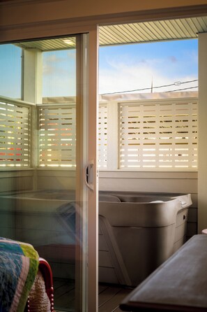 A room with a sliding glass door leading to a balcony with a white fence. - 2BR/2BA Hot Tub Suite • Coat of Many Colors (Sevierville)