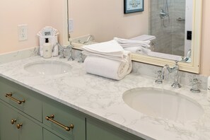 Une salle de bain avec deux lavabos, un miroir et un porte-serviettes.
